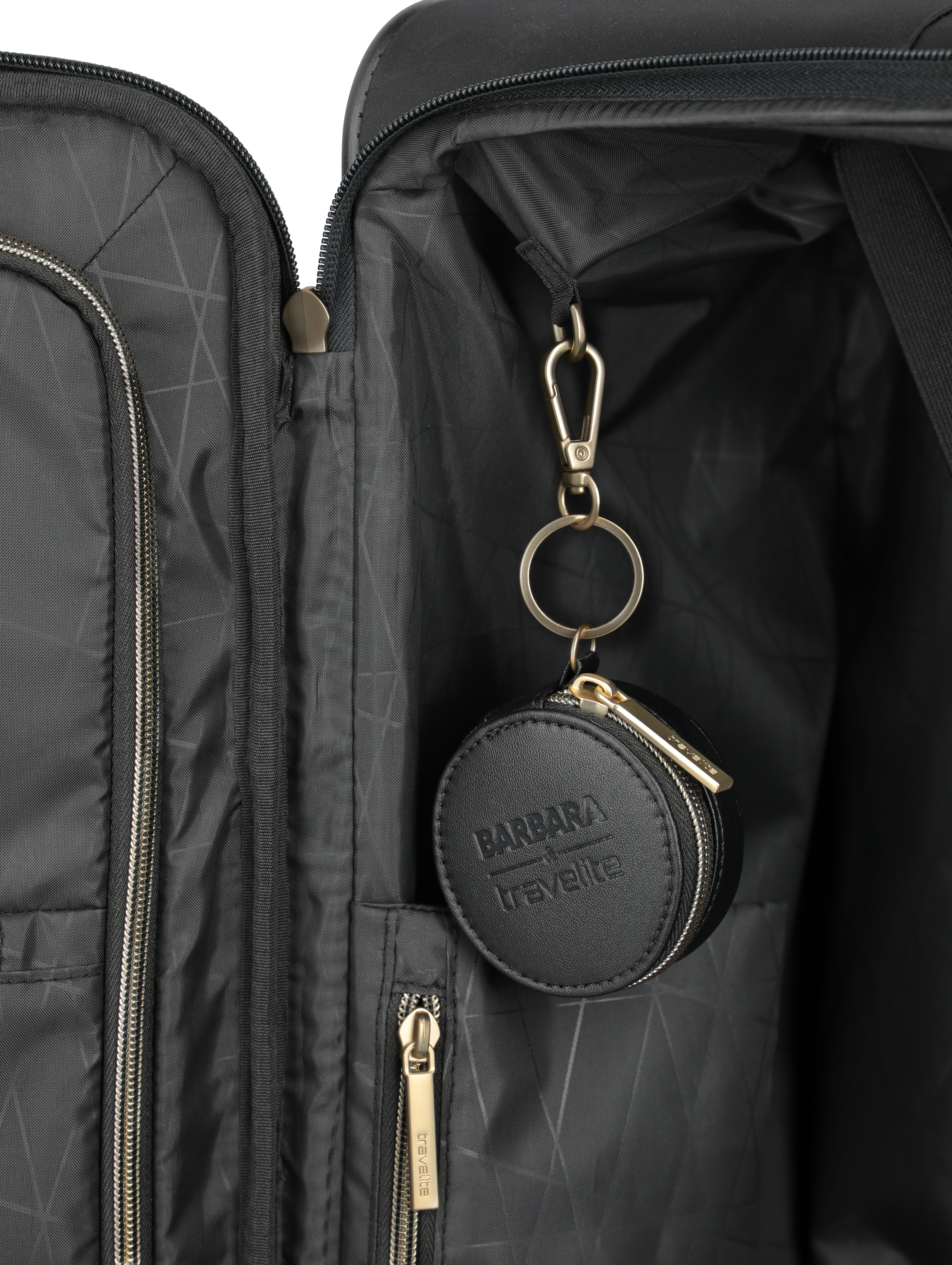Innenansicht eines schwarzen Koffers mit goldfarbenem Reißverschluss und rundem Leder-Etui von travelite mit Schlüsselanhänger.