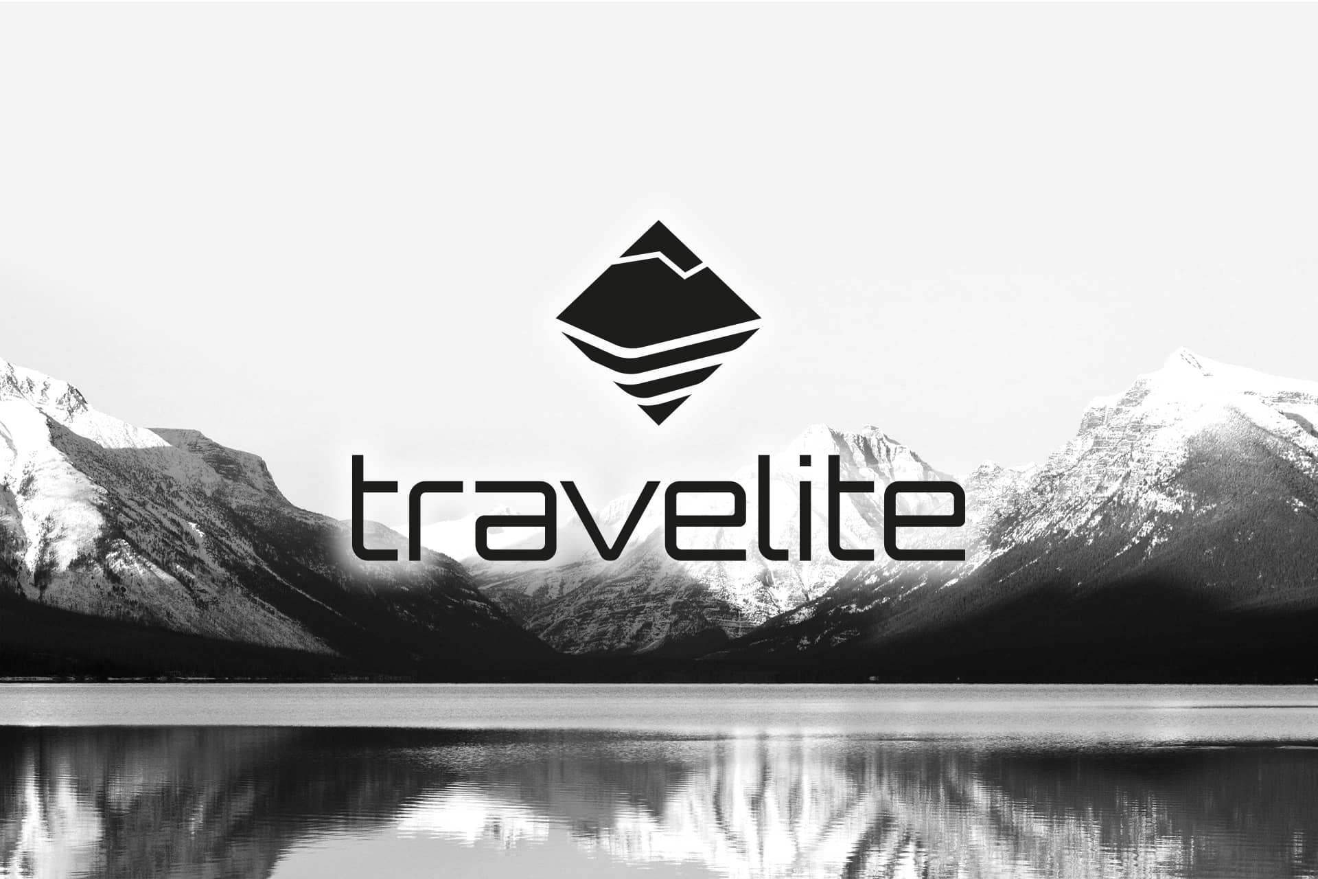 Travelite-Logo mit Berglandschaft im Hintergrund Schwarz-Weiß-Bild mit Travelite-Logo vor einer Bergkulisse und einem See