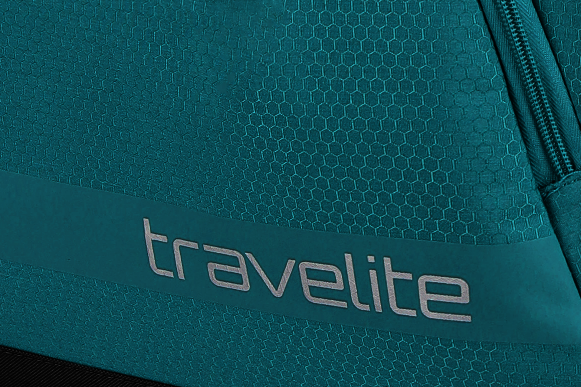 Detailansicht einer Travelite Reisetasche mit Reißverschluss und Wabenstruktur in Türkis Nahaufnahme einer türkisfarbenen Travelite Reisetasche mit Wabenmuster und sichtbarem Reißverschluss