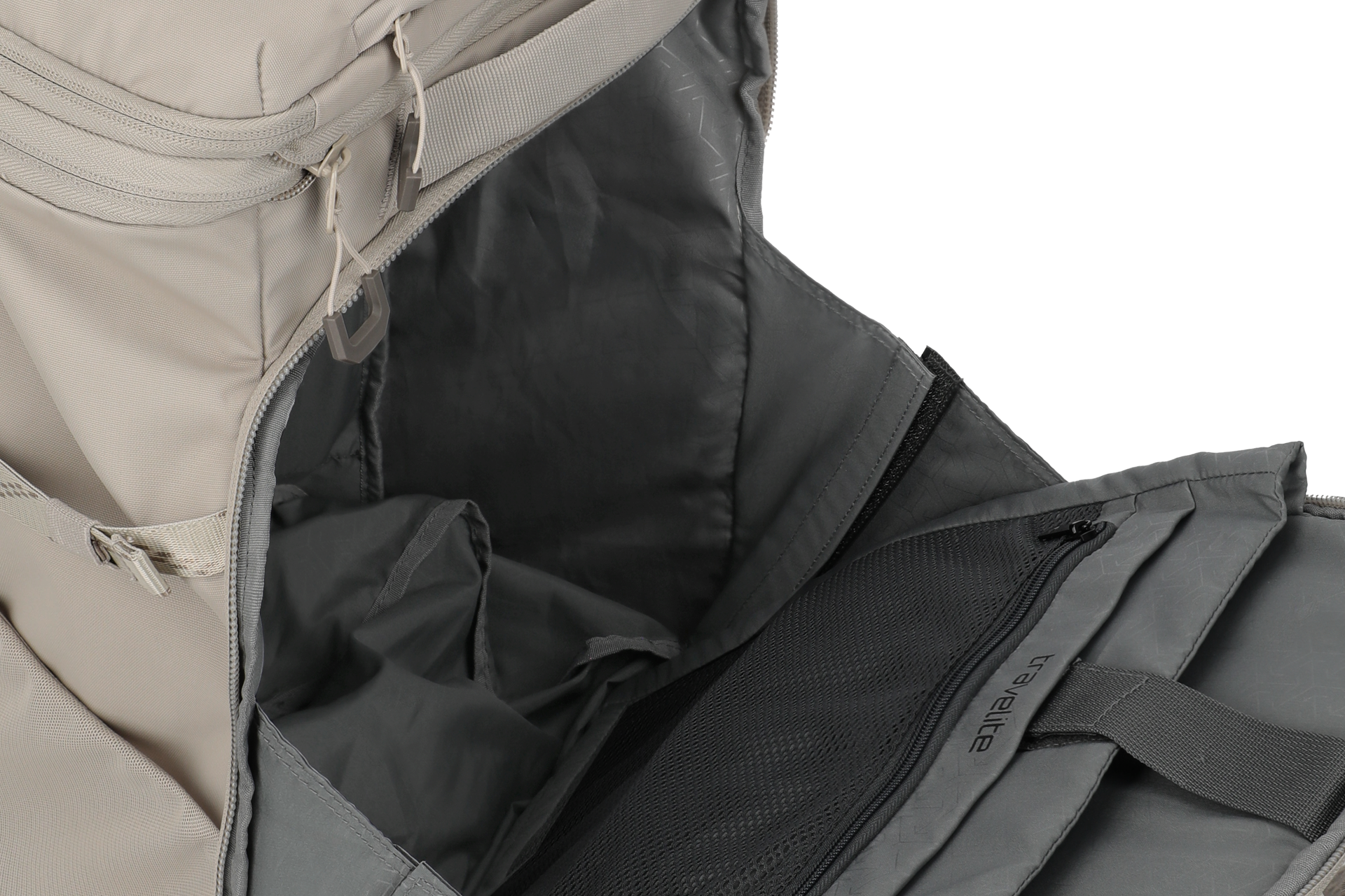 Primer plano de una mochila parcialmente abierta. Se puede ver el forro interior gris y un bolsillo de malla con cremallera. El exterior de la mochila es de color beige más claro. Se ven las cremalleras y las correas.