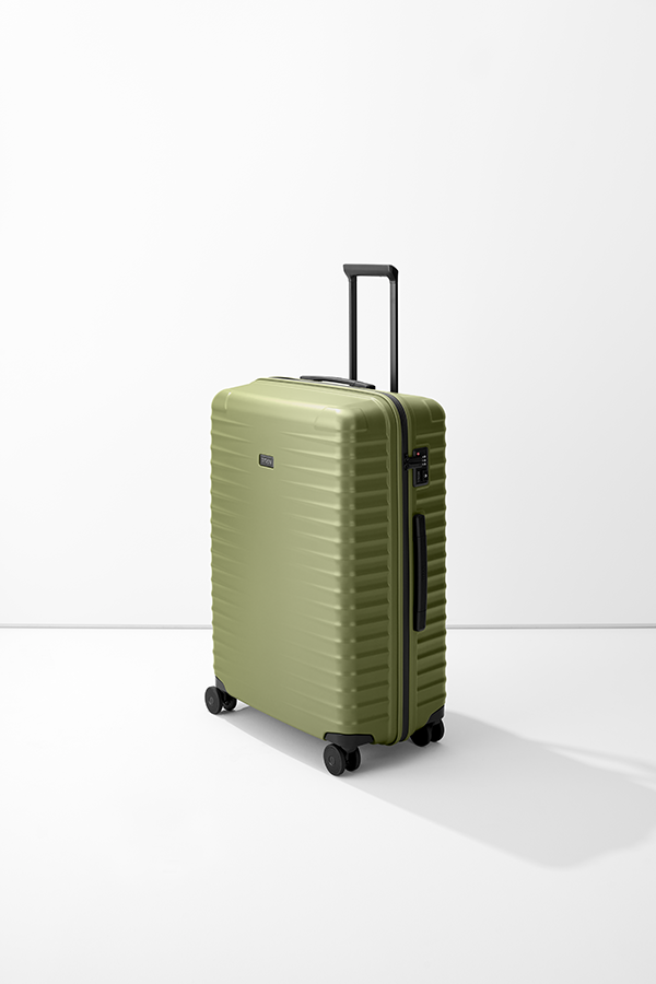 Valigia rigida verde oliva di grandi dimensioni "TITAN Trolley L" su base bianca, con asta telescopica, quattro ruote e chiusura a combinazione. La valigia presenta linee orizzontali e un piccolo logo del marchio.