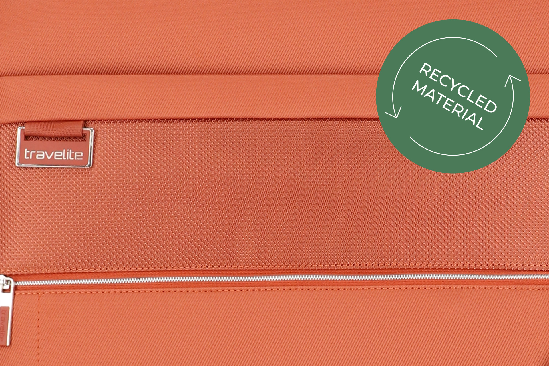 Travelite Koffer aus recyceltem Material in Orange Nahaufnahme eines orangefarbenen Travelite Koffers mit Logo und Hinweis auf recyceltes Material