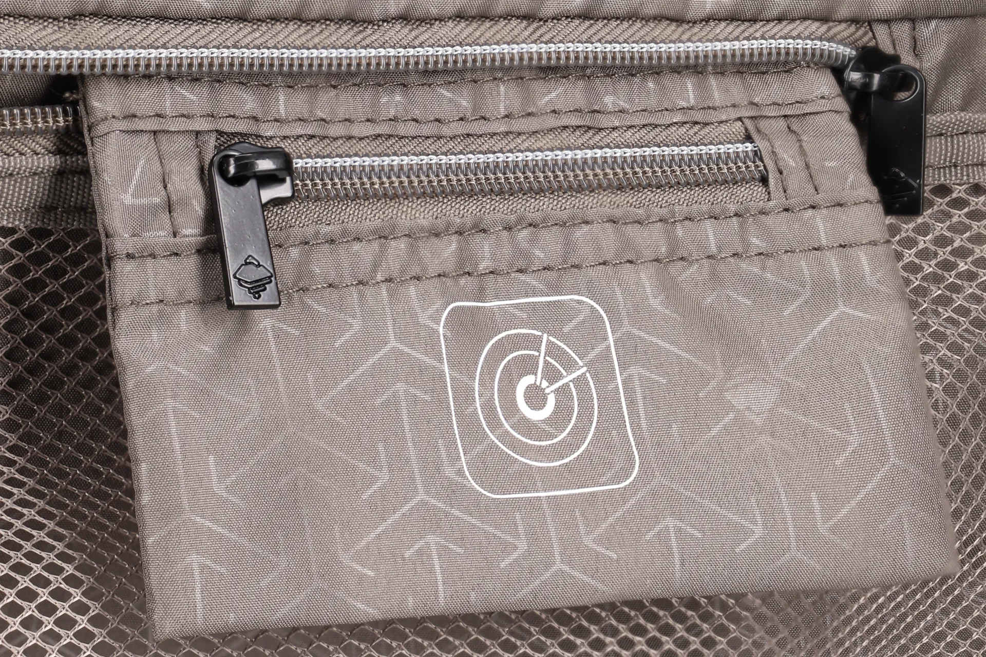Detailansicht einer Innentasche aus Stoff mit Reißverschluss und Pfeilmuster, geeignet für Rucksäcke oder Taschen Nahaufnahme einer grauen Innentasche mit Reißverschluss und Pfeilmuster, ideal für die Aufbewahrung kleiner Gegenstände in einem Rucksack