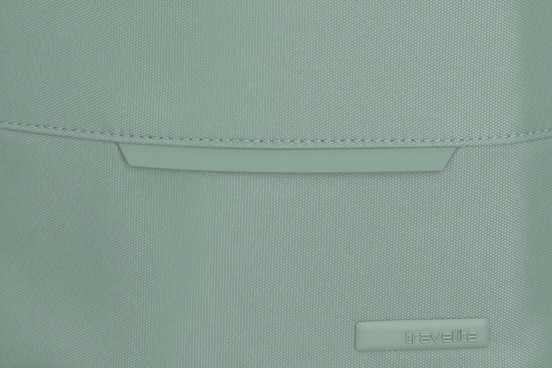 Detailansicht einer mintgrünen Travelite-Tasche aus Textilgewebe Nahaufnahme des Materials und Logos einer mintgrünen Tasche der Marke Travelite