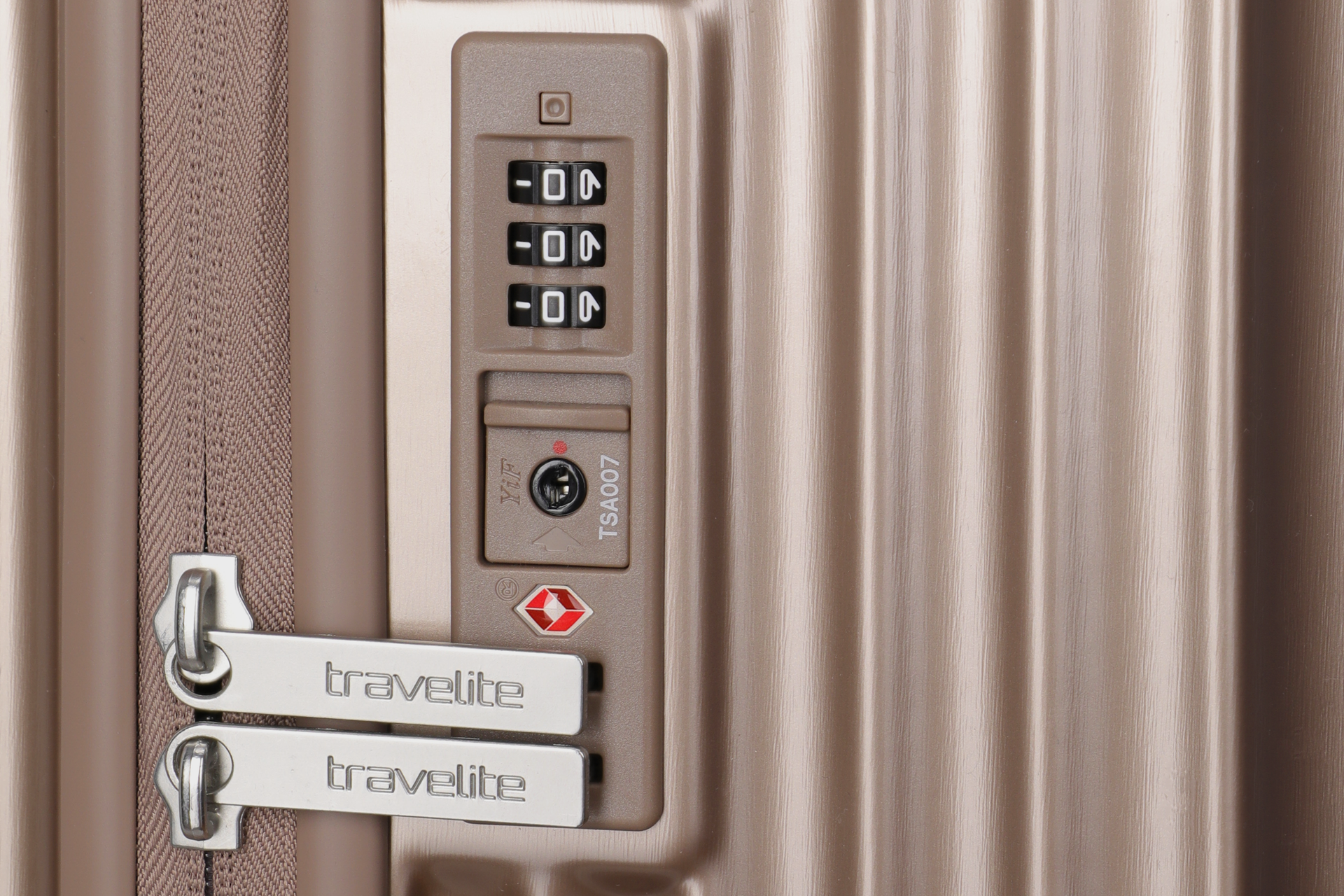Detailansicht eines TSA-Zahlenschlosses am Reißverschlusskoffer von travelite in Champagnerfarbe Nahaufnahme eines goldfarbenen Koffers mit integriertem TSA-Zahlenschloss und travelite-Reißverschlusszippern