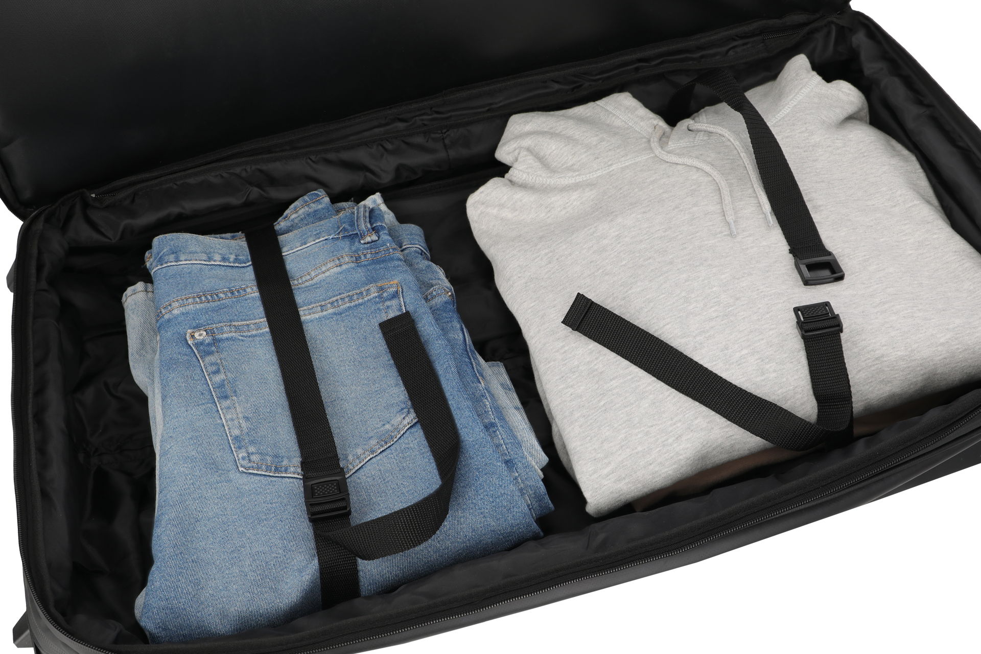 Bepackte Rollenreisetasche von travelite in Schwarz EIne Jeans und ein Pullover mit Packgurten in einer schwarzen Rollenreisetasche von travelite