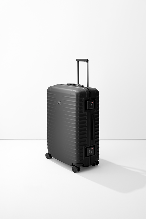 Un trolley L nero TITAN poggia su una base bianca. La valigia ha una superficie a coste e una maniglia estensibile. Sul lato sono visibili due lucchetti TSA. La valigia poggia su quattro ruote doppie.