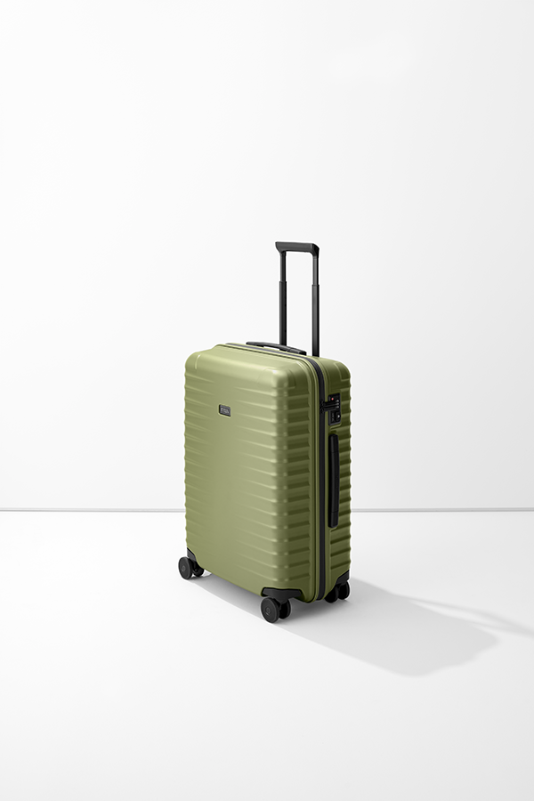 Un trolley verde oliva M di TITAN si erge su uno sfondo bianco. La valigia ha una superficie a coste e accenti neri, tra cui la maniglia e le quattro ruote. Sul lato è presente una serratura a combinazione.