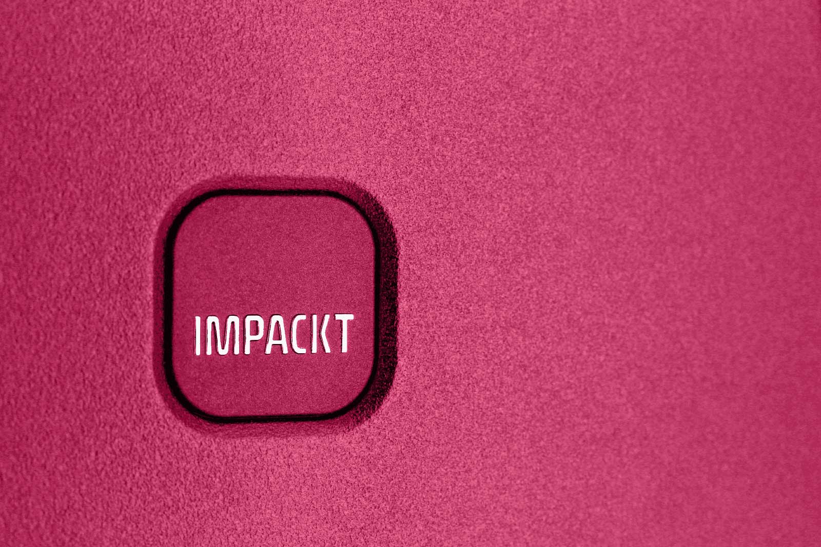 Nahaufnahme eines pinkfarbenen Hintergrunds mit quadratischem Logo mit der Aufschrift 'IMPACKT'