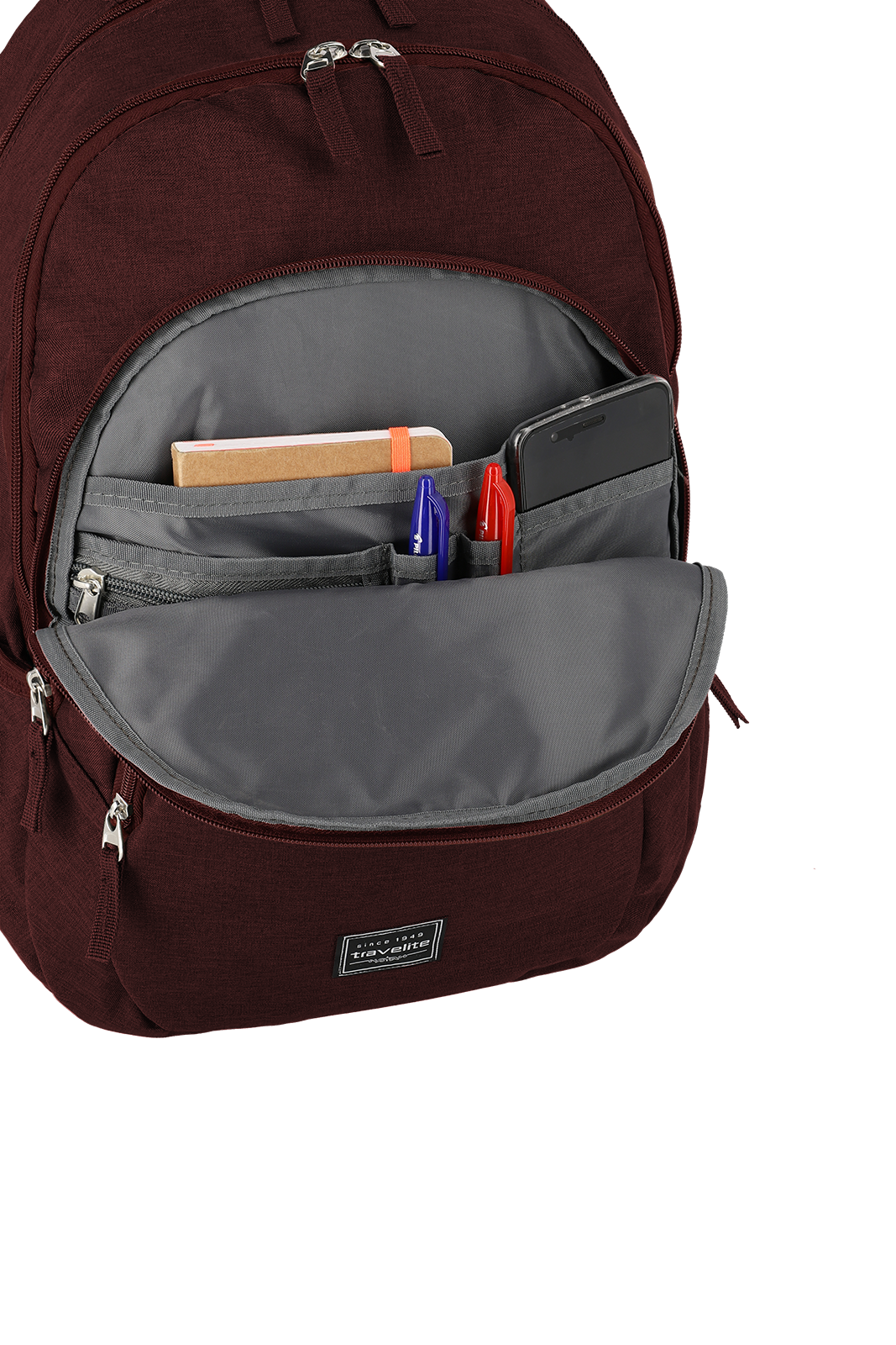 Roter Rucksack mit geöffnetem Frontfach, das ein Notizbuch, zwei Stifte und ein Smartphone enthält
