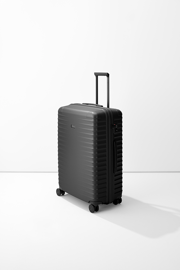 Un grande trolley L di TITAN, di colore nero e con manico telescopico, si trova davanti a uno sfondo bianco. La valigia ha una superficie scanalata. Sul lato è presente una serratura a combinazione. Sotto il carrello sono montate quattro piccole ruote.