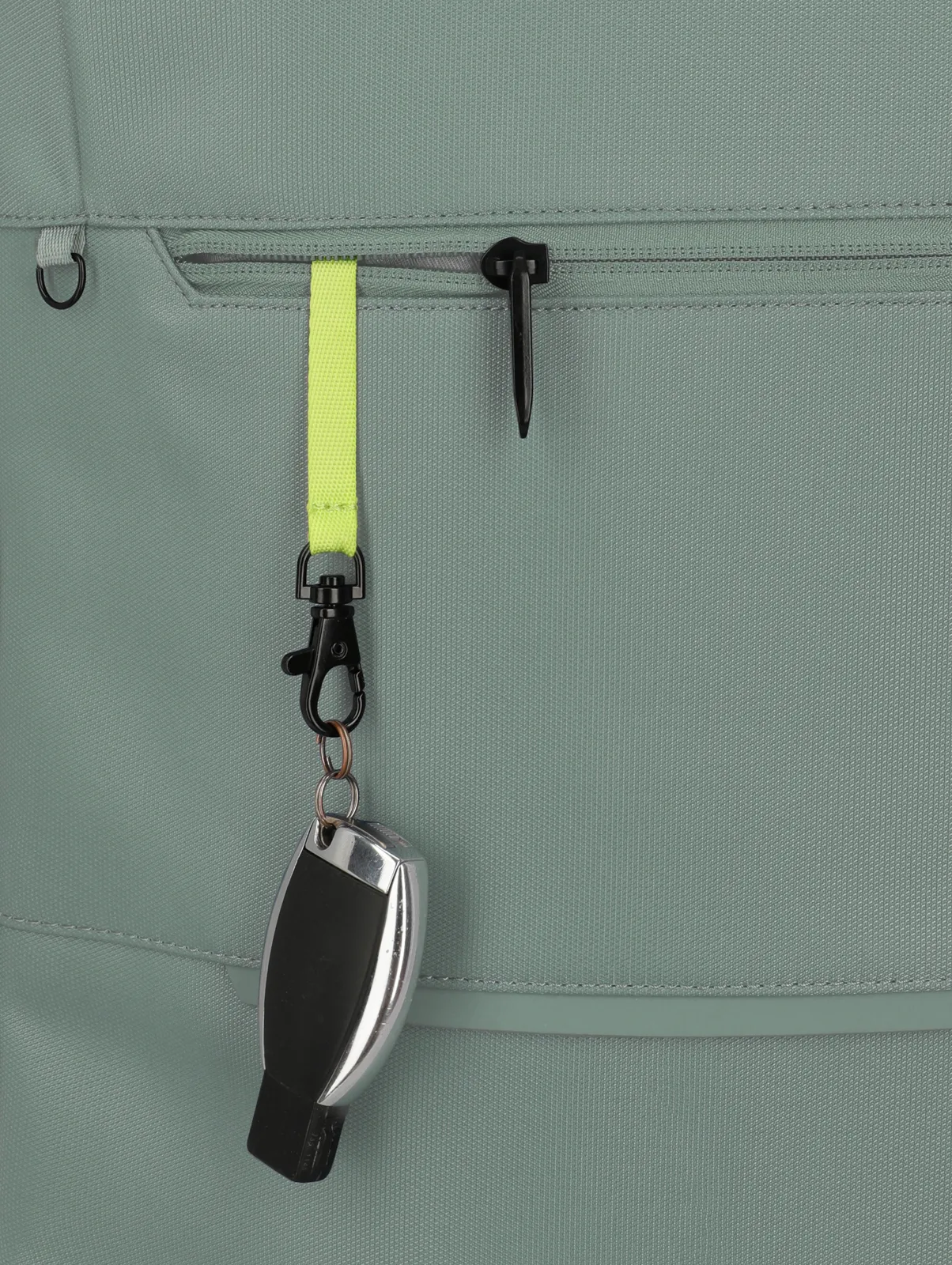Detailansicht eines grauen Rucksacks mit gelbem Schlüsselband und Autoschlüssel an der Fronttasche
