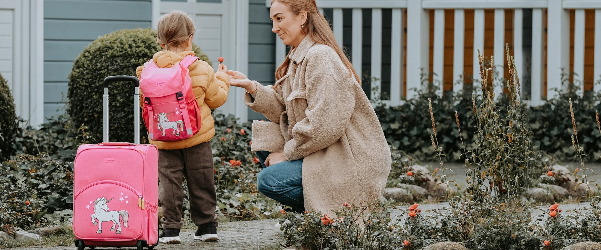 Kindergepaeck in rosa Mama und Kind mit einem Kinderrucksack und einem Kinderkoffer