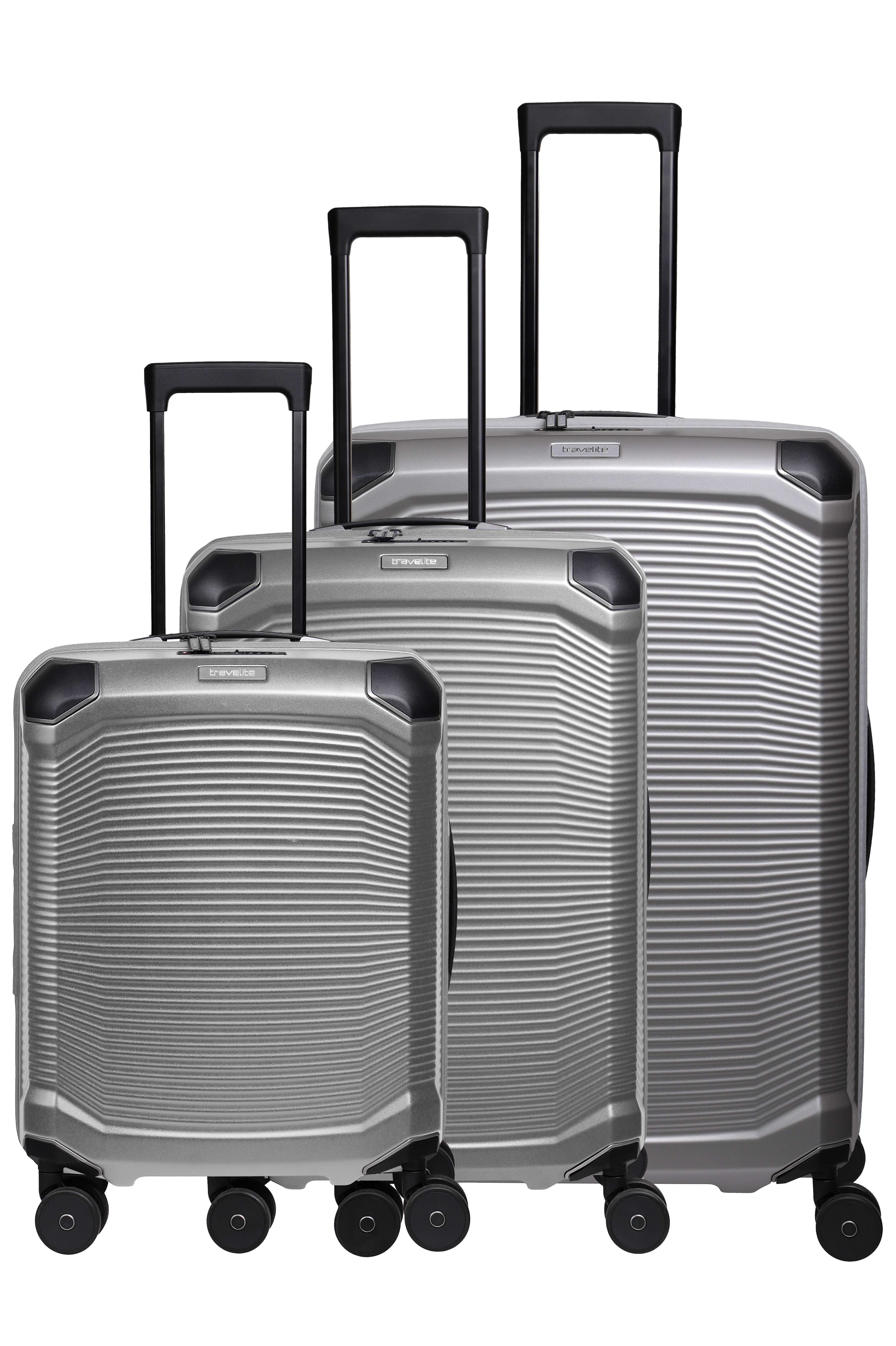 Trois valises trolley argentées de différentes tailles sur fond noir. Elles ont un corps nervuré, quatre roulettes noires et une poignée télescopique noire. Une étiquette argentée portant l'inscription "travelite" est apposée sur chaque valise.