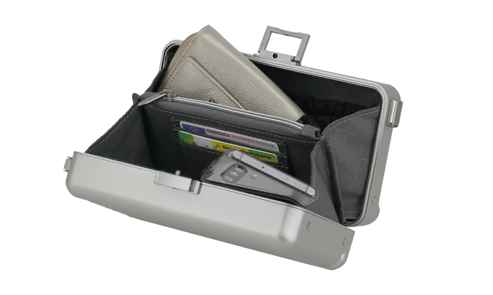 Robuste Metallkassette mit geöffnetem Deckel, zeigt Brieftasche und Kartenfächer Eine geöffnete Metallkassette mit einer grauen Brieftasche und mehreren Kartenfächern