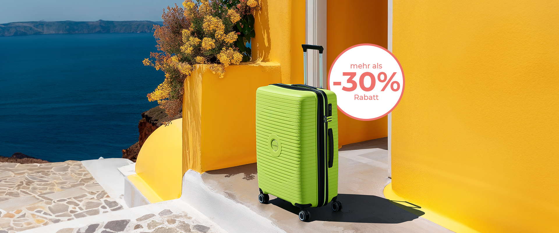 Ein grüner Rollkoffer steht vor einer gelben Wand mit einem Rabatt von über 30%, das blaue Meer im Hintergrund